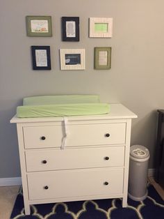 a baby crib in the corner of a room with pictures on the wall above it