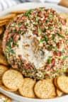 a cheese ball on top of crackers in a bowl