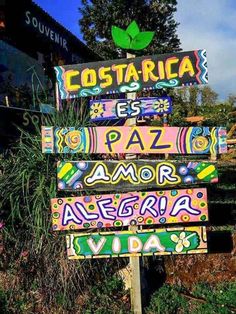 a sign that is sitting in front of some plants and flowers with the words costa rica written on it