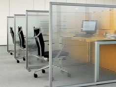 an office cubicle with four chairs and a desk