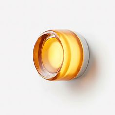 an orange glass cup sitting on top of a white table