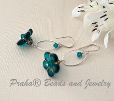 Great earrings for spring and summer...teal Czech glass flower beads are accented with gold trim. Teal beads measure 15MM, with a depth of 6MM. Earrings have Swarovski crystal accents and bright sterling silver oval components. The earrings measure just over 1 3/4" from the top of the handcrafted sterling silver ear wire. This bead is made by using the Pressed Glass method. All sterling silver components. Elegant Turquoise Flower Earrings Nickel Free, Turquoise Czech Glass Flower Earrings For Gift, Blue Czech Glass Teardrop Jewelry, Adjustable Blue Flower Earrings With Czech Glass, Elegant Turquoise Nickel-free Flower Earrings, Earrings For Spring, Blue Czech Glass Flower Earrings, Turquoise Czech Glass Dangling Beads Earrings, Flower Drop Earrings