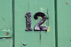 the number twenty two is painted on an old green door