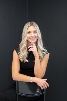 a woman sitting on top of a black chair