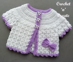 a crocheted sweater with a bow on the front and purple trimmings