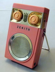 an old pink radio sitting on top of a table