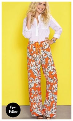 a woman standing in front of a yellow wall wearing an orange and white floral print pants