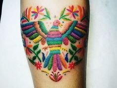 a colorful bird tattoo on the leg