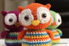 two stuffed animals sitting next to each other on top of a bed covered in crochet