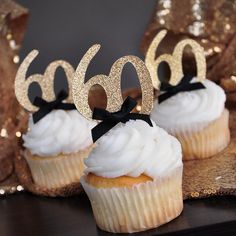 two cupcakes with white frosting and black bows