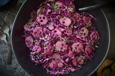 a bowl filled with red cabbage and skulls