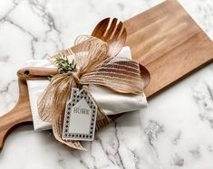 two wooden utensils tied with twine on top of a marble countertop