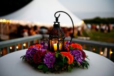 a candle is lit on top of a table with flowers