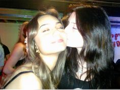 two women are kissing each other at a party