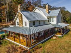 an aerial view of a house in the fall with lots of windows and covered porches