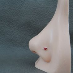 a white ceramic head with a red heart on it