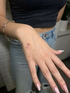 a woman's hand with a small star tattoo on it