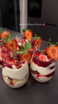 four desserts with strawberries in them on a table