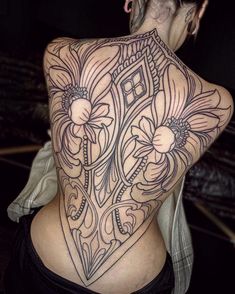 the back of a woman's body with tattoos on it