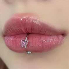 a woman's lips with pink lipstick and piercing