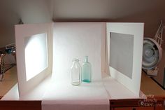 two empty glass bottles sitting inside of a white box