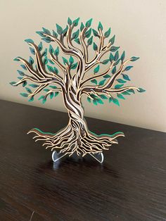 a metal tree sculpture sitting on top of a wooden table