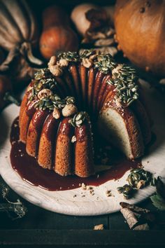 a bundt cake covered in nuts and drizzled with sauce