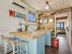 a kitchen with two stools in front of the counter and a sign on the wall