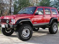 a red jeep is parked on the street