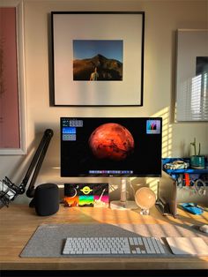 a computer monitor sitting on top of a wooden desk next to a keyboard and mouse