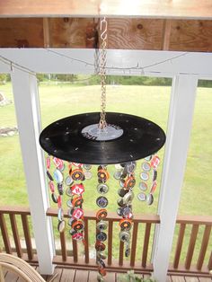 a wind chime hanging from a porch in front of a window with lots of buttons on it