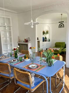 a blue table with chairs and plates on it