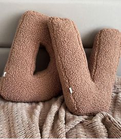 two pillows sitting on top of a bed with the letter u in it's middle