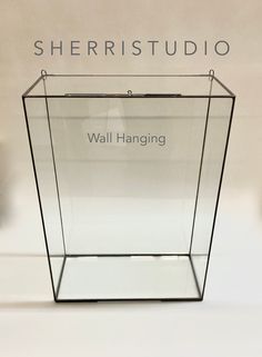 a glass box with the words wall hanging on it's front and side sides