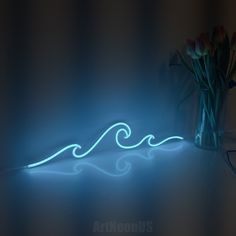 a vase filled with flowers sitting on top of a table next to a blue light