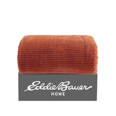 an orange towel on top of a gray box with the words eddie bauer home