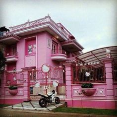 a motorcycle parked in front of a pink house