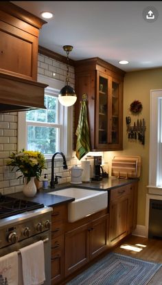 a kitchen with wooden cabinets and an oven in the center, sink is surrounded by towels