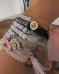 a close up of a person's arm wearing bracelets with charms on them