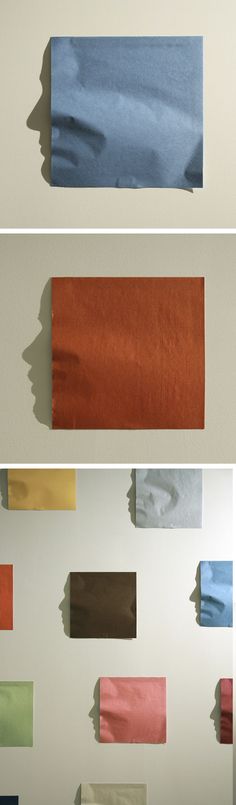 several different colors of tissue paper on a wall