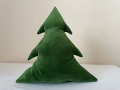 a green christmas tree pillow sitting on top of a white table