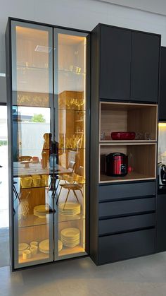 a kitchen with black cabinets and yellow plates on the counter top in front of glass doors