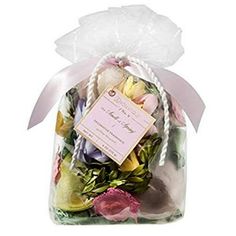 a bag filled with lots of flowers on top of a white table next to a pink ribbon