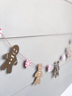 gingerbreads and candy are strung on a string with twine to match the wall