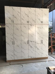 a large white cabinet sitting inside of a garage