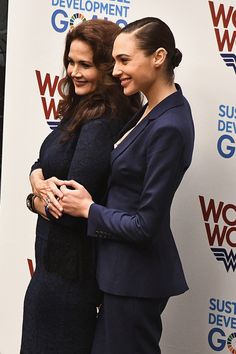 two women standing next to each other on a red carpet