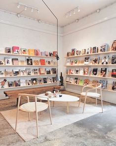 two chairs and a table in a room with bookshelves