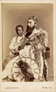 an old black and white photo of a man with a beard sitting on a wheel