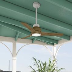 a ceiling fan is mounted on the side of a porch next to an ocean view