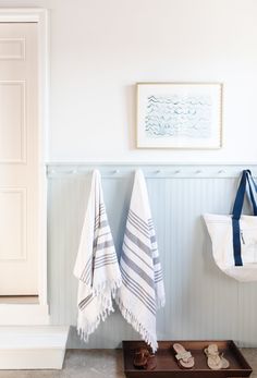 two towels hanging on the wall next to shoes